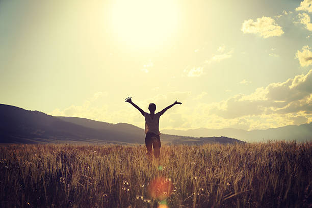 istock young freedom woman open arms at sunset prairie 607614278