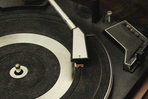 Record player stylus on a rotating disc, Picture of a vinyl record playing. (Vintage Style Process)