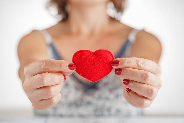 istock woman holding a heart symbol in her hands 607618462
