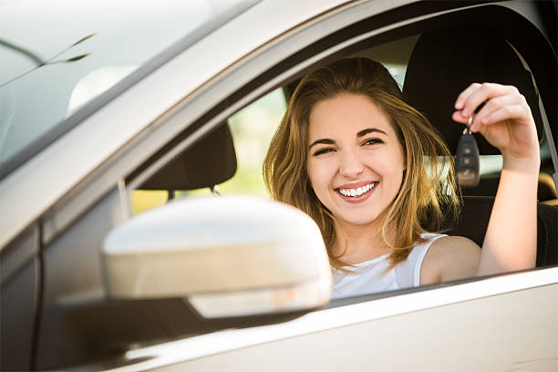 最初の車 - キーを持つ若い女性 - car driving inside of indoors ストックフォトと画像