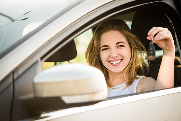 First car - young woman with keys stock photo