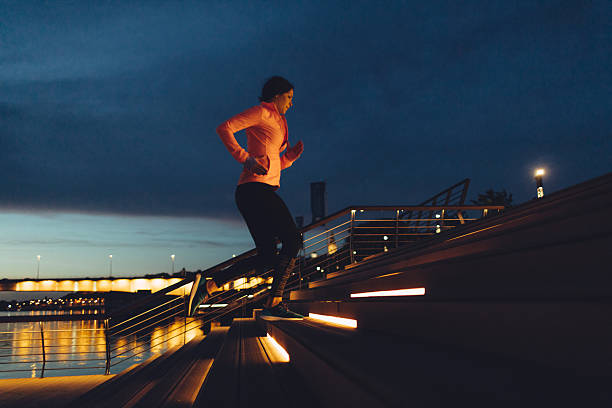 mujer joven para correr por la noche, cerca de río. - running jogging urban scene city life fotografías e imágenes de stock