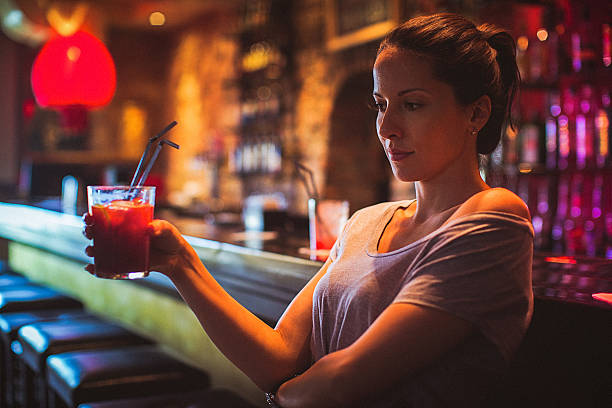 istock Young woman drinking cocktail in a cocktail bar 607623512