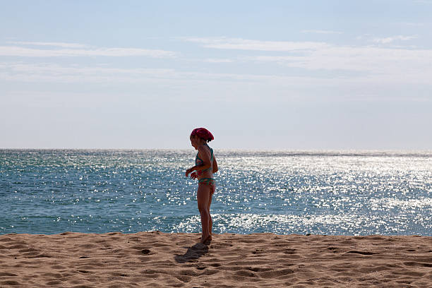 Girl walking on sandy beach