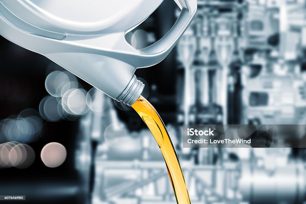 Pouring motor oil on engine background Lubrication Stock Photo