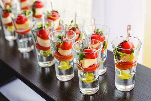 Small snacks canape with cherry tomatoes, cheese, olives on skewers