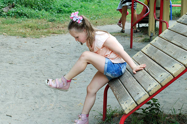 istock Small girl looks at her bruise 607648602