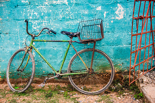 istock old green bicycle by teal wall and red gate 607650512