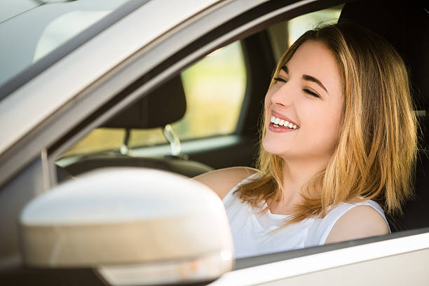 istock Young woman driving car 607651050
