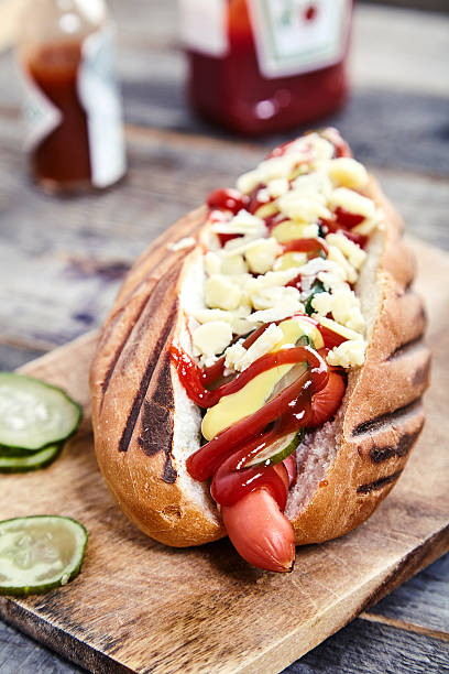 istock Hot dog with pickles, ketchup, mustard and cheese 607651246