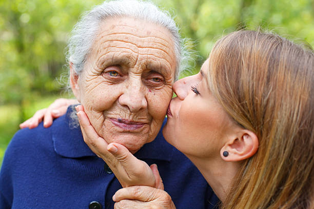 młoda kobieta całuje swoją piękną babcię - aging process women human face daughter zdjęcia i obrazy z banku zdjęć