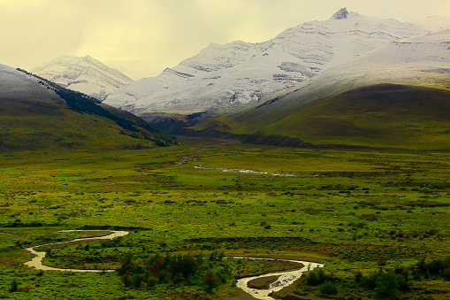 River stream into Snowcapped Patagonia Andes, steppe landscape, Chalten, Argentina