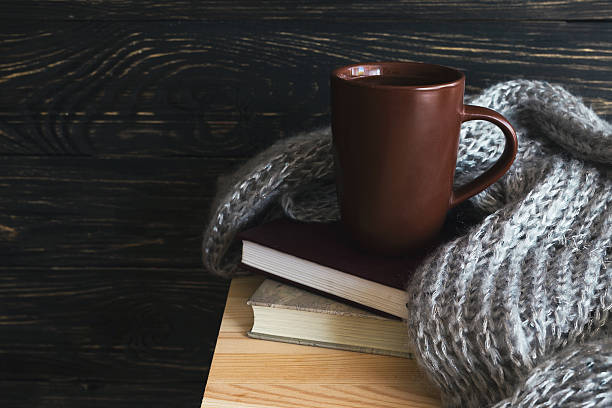 istock Warm knitted plaid, cup of tea and books 607654474