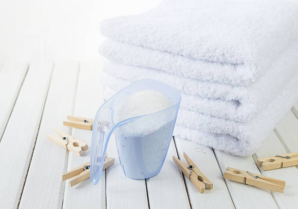 asciugamani da bagno, detersivo in tazza di misura e molletta in legno - laundry detergent cleaning product concepts measuring cup foto e immagini stock