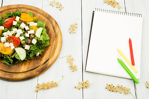 istock salad of fresh vegetables and a blank notebook 607655398