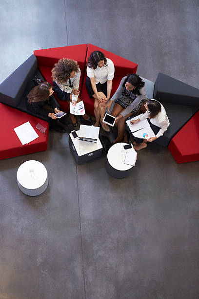 Overhead Shot Of Businesswomen Meeting In Lobby Of Office Overhead Shot Of Businesswomen Meeting In Lobby Of Office five people photos stock pictures, royalty-free photos & images