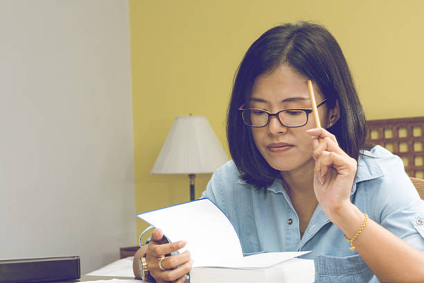 istock Woman writing in a book with a Pencil 607729800