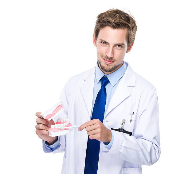 istock Dentist holding dentures and toothbrush 607730108