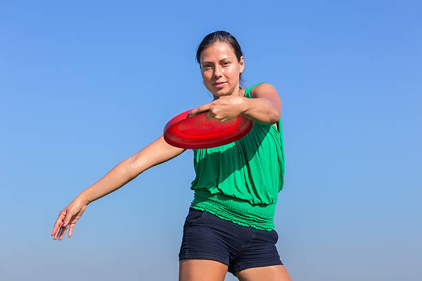 Dutch woman throwing orange disc in sky