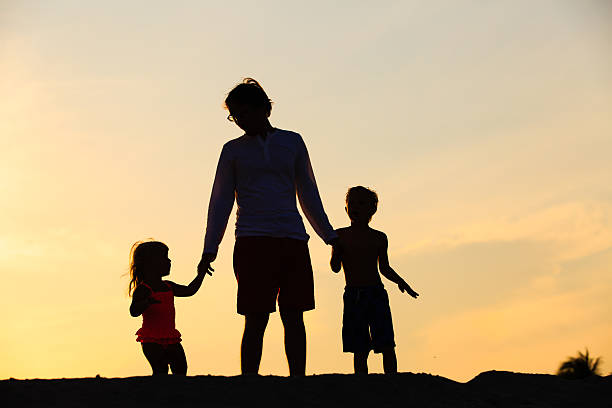 istock father with son and daughter walking at sunset 607732434