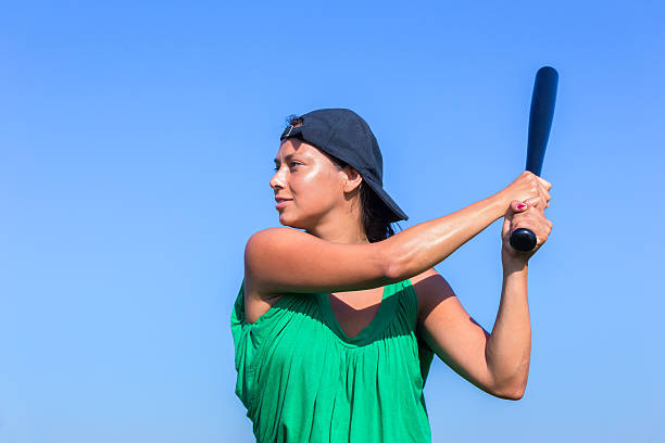 istock Young woman with baseball bat and cap 607733094