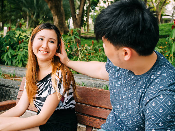 istock Asian couple playing with each other in the park 607736932