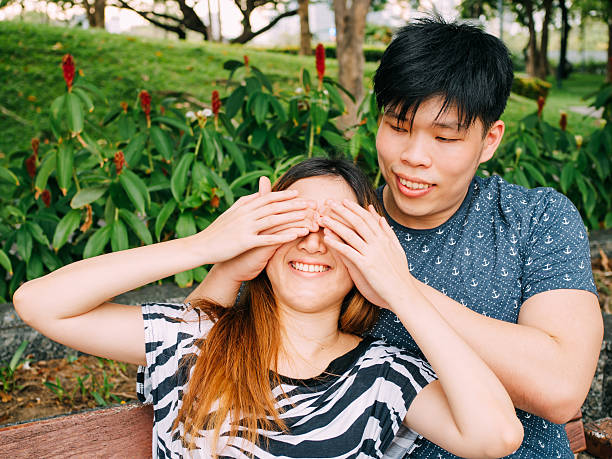 istock Asian couple playing with each other in the park 607737002