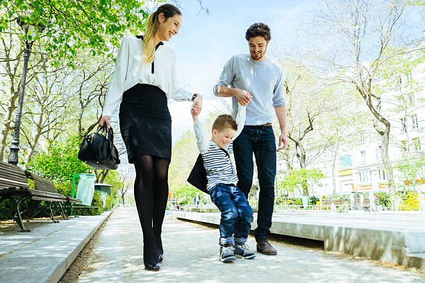 istock Happy Family Walking Through The Park Taking Son to School 607737110