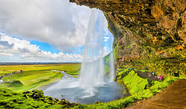 auf der rückseite des seljalandsfoss wasserfalls - island - waterfall iceland landscape stream stock-fotos und bilder