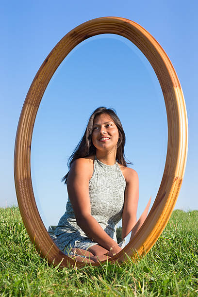 Mirror in grass with mirror image of woman