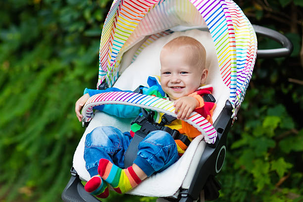 istock Baby boy sitting in white stroller 607739388