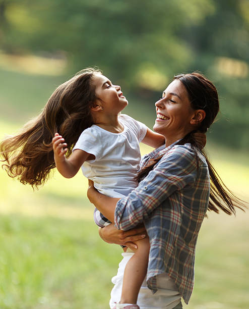 madre e figlia che giocano girando intorno al parco. - family nature healthy lifestyle happiness foto e immagini stock