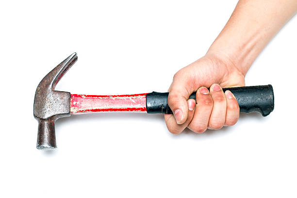 istock hand holding the steel hammer 607741330