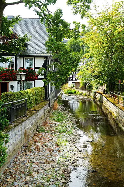 Rivulet and half-timbered hoes in Oberkirchen in Sauerland. North Rhine Westfalia.