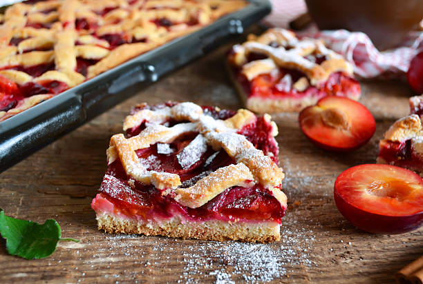 istock Sand cake with plums on a wooden background 607745022