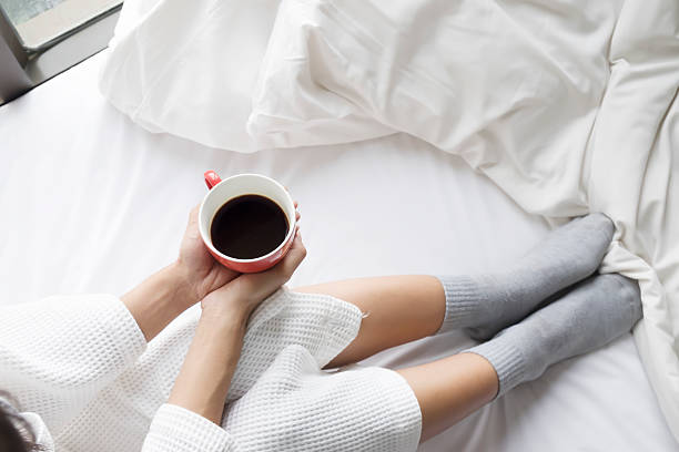 istock Relaxing with hot coffee on the bed in the morning. 607747180