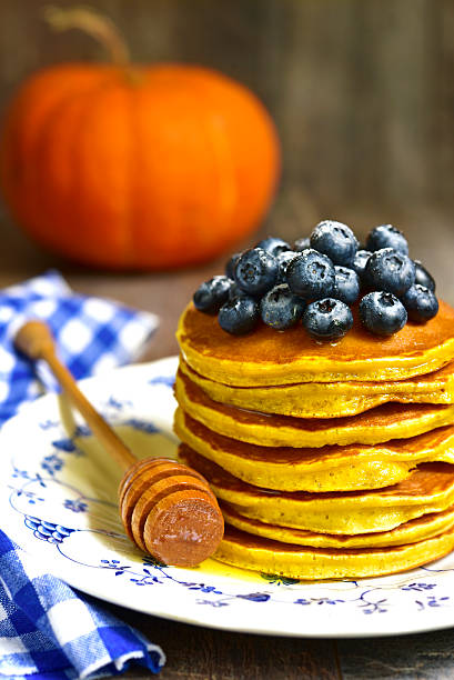 istock Pumpkin pancakes with fresh blueberry and honey. 607747804