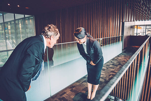 Senior Caucasian Businessman and Young Japanese Entrepreneur Bowing, Kyoto, Japan stock photo