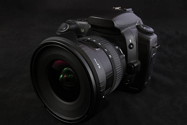 istock Black camera with wide angle lens isolated on black background 607749714
