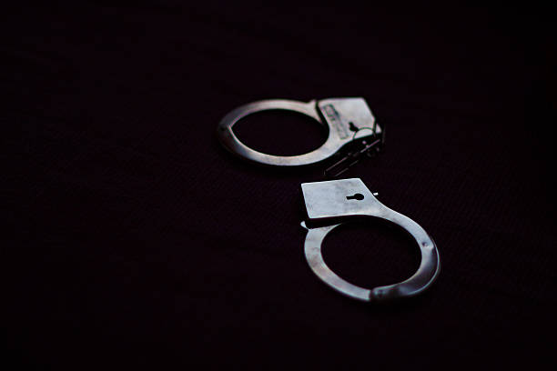 istock Pair of Handcuffs in dark 607750892