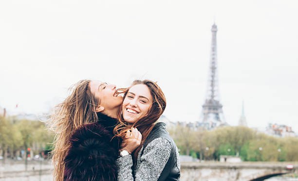 istock Young female friends having fun in front of Eiffel tower 607750932
