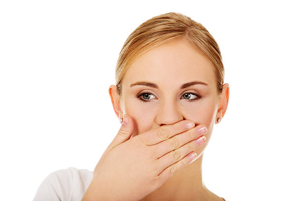 istock Young woman covering her mouth with hand 607750948