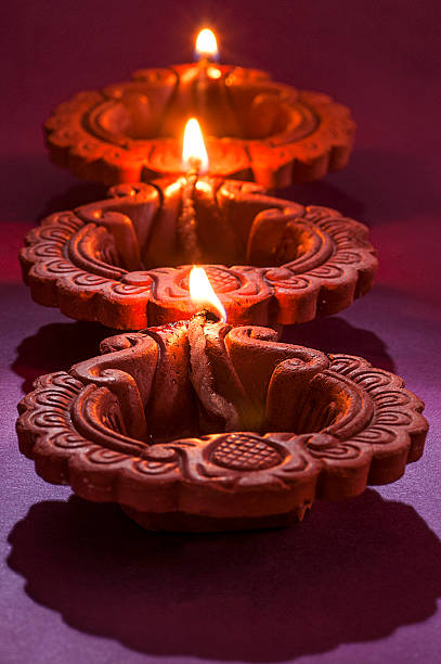 clay diya lamps lit during diwali celebration. greetings card design - vertical bright brightly lit vibrant color imagens e fotografias de stock
