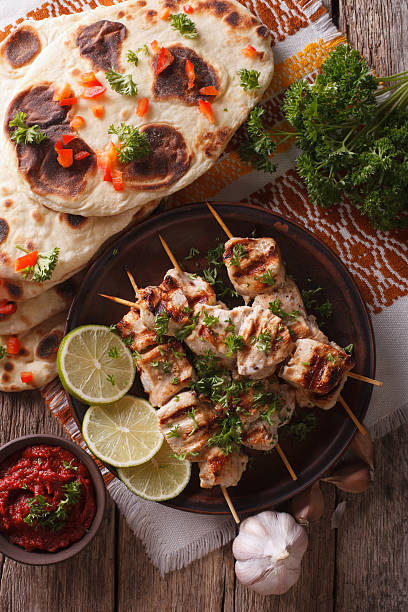 istock Chicken tikka on skewers, naan flat bread closeup. vertical 607751850