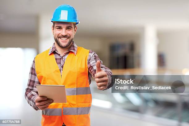 Trabajador Manual Sonriente En El Gesto Del Casco Azul Pulgar Hacia Arriba Foto de stock y más banco de imágenes de Seguridad