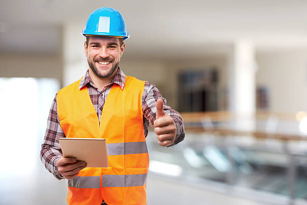 улыбаясь ручной работник в синий шлем жест вверх - manual worker portrait helmet technology стоковые фото и изображения