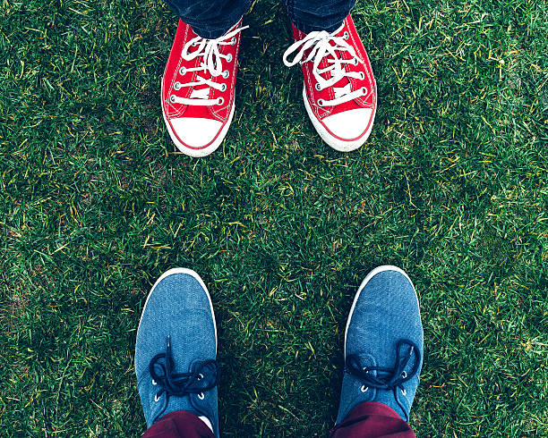 istock youth sneakers on legs and grass during sunny summer day 607757516