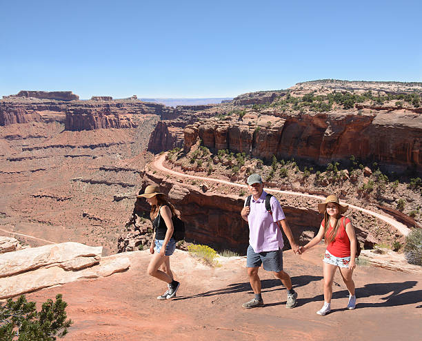 istock Family with backpacks hiking on summer vacation. 607758404