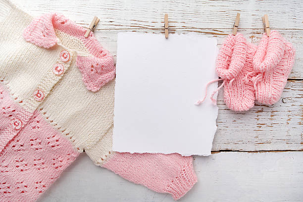 baby girl clothes with blank card on white wooden background - paper stack heap index card imagens e fotografias de stock