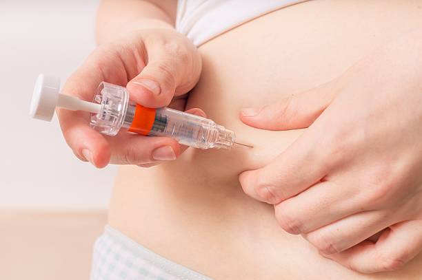 IVF and infertility treatment. Patient is injecting hormones to abdomen. IVF and infertility treatment concept. Patient is injecting hormones to abdomen with syringe. medicate stock pictures, royalty-free photos & images